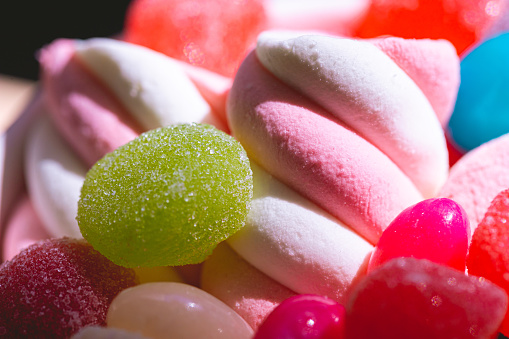 Assorted candies in macro photography.  Among them: marshmallow and gum drops.
