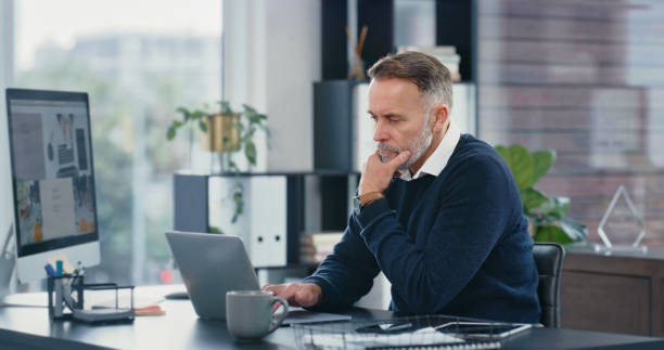 istock Corporate accountant working on a laptop and computer doing accounting research in a modern office. Businessman analyzing stocks, stats and finance economy to create financial freedom with technology 1419659490