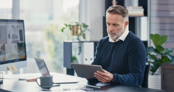 istock Web and internet search on a digital and computer tablet with a old fintech business man. IT tech developer worker working on software research on cloud computing, big data and ui web strategy for ux 1419660617