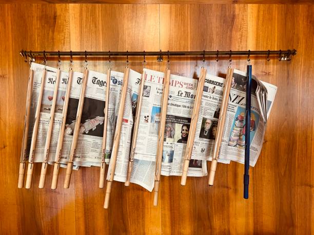 Sils Maria, Swizerland - August, 22 - 2022: International newspapers hanging at a wooden wall in a public library.