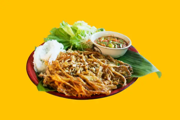Thai papaya salad or Somtum with rice noodles and vegetable, Fried som tam , Front view with yellow background