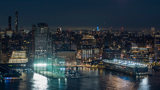 Chelsea Piers, illuminated at night seen from the Hudson River, with Manhattan city view.
