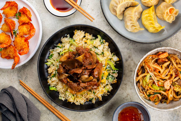 istock Assorted Chinese Asian food. Table with Rice and vegetables, stir fried beef, vegetables, bamboo and mushrooms, fried shrimps, dim sum dumplings, udon noodles, soy and sweet sauces. Chinese restaurant concept. 1419671183