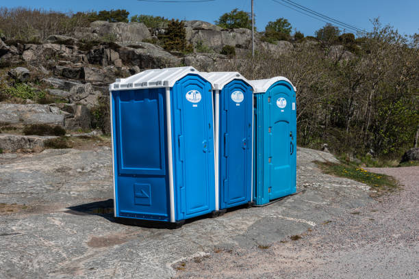 Gothenburg, Sweden - May 07 2022: Three blue portable toilets by a beach.