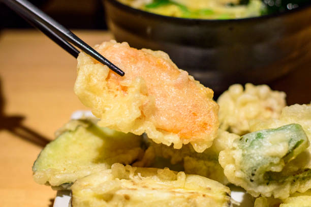 Closeup of chopsticks picking up Japanese vegetable tempura stock photo