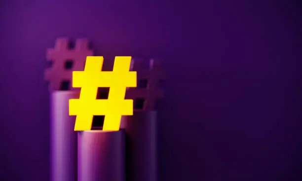 Yellow hashtag symbol glowing before purple background. Horizontal composition with copy space. Standing out from the crowd concept.