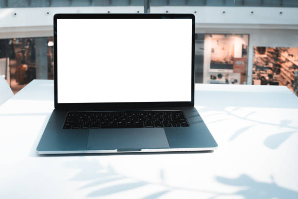istock Laptop mockup with white screen in business office or shopping mall. Empty copy space, blank screen mockup. Soft focus laptop with interor background. Travel, study and office work concept 1419678837