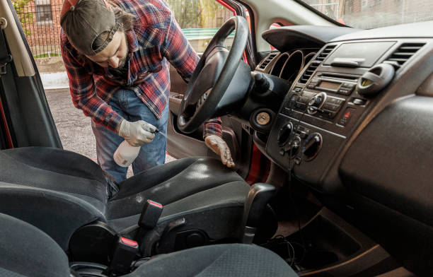 istock Professional cleaner spraying driver car seat with special detergents to remove stains during car wash. 1419681303