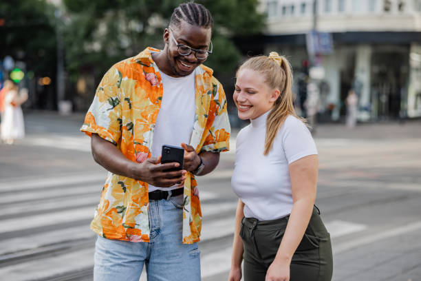 istock Multiracial couple smiling and using phone 1419681748