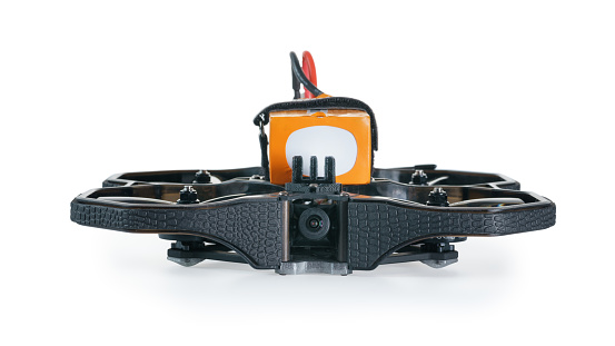 Black FPV cinewhoop drone with battery front view with selective focus. Isolated on white, clipping path included