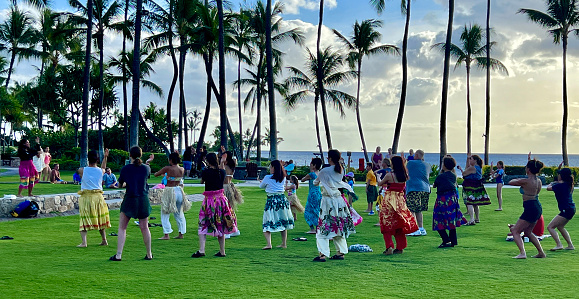 A group of tourists participate in a hula lesson at a Hawaii resort