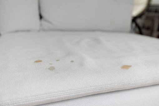 White coach with stains from coffee before cleaning.