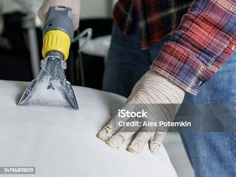 istock Dirty water bubbling in the nozzle of washing vacuum. Worker using professional vacuum-cleaner for deep washing. 1419689809