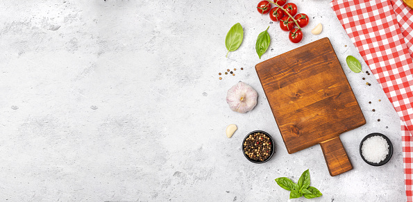 Wooden cutting board and spices, herb for food on black stone table. Menu, recipe mock up, banner background with copy space for text. Top view