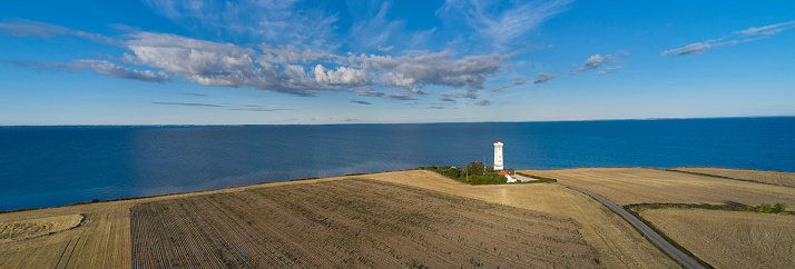 Danish island Helnaes with typical lighthouse seen from drone point of view.