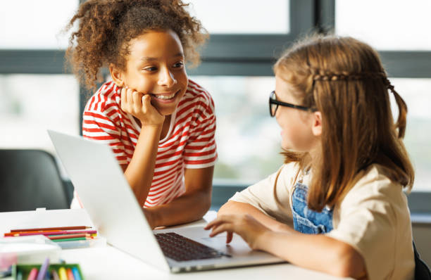 istock Cheerful  schoolgirls doing a school assignment using a laptop during online lesson 1419698963