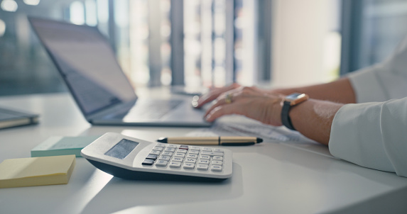 Professional finance accountant working on laptop at work, typing emails on computer and planning with internet at table in office. Professional corporate worker networking and searching online