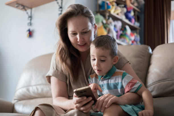 istock Mother And Son Choosing Toys To Buy Using Smart phone 1419704290