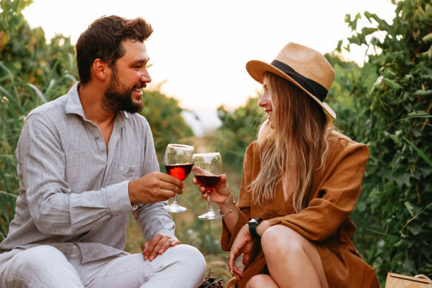 istock Couple clinking red wine glass in a Vineyard during sunset. 1419704735
