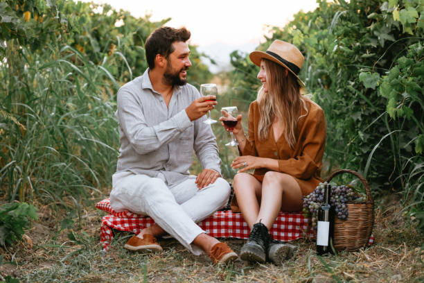 istock Couple clinking red wine glass in a Vineyard during sunset. 1419704839
