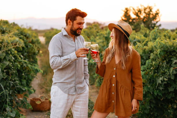 istock Couple clinking red wine glass in a Vineyard during sunset. 1419705009