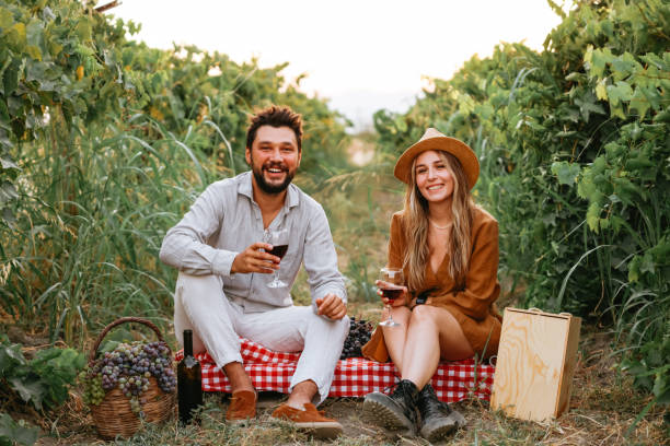 istock Couple clinking red wine glass in a Vineyard during sunset. 1419705813