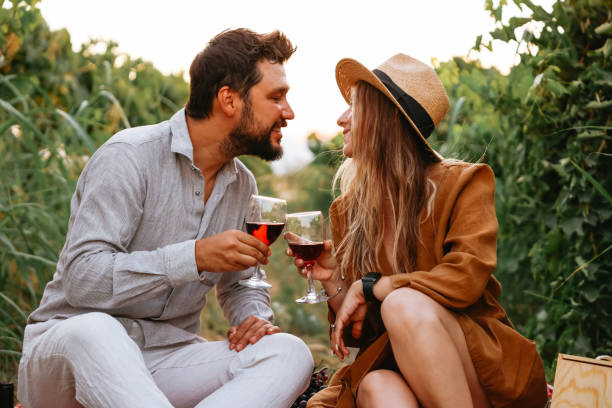 istock Couple clinking red wine glass in a Vineyard during sunset. 1419705915