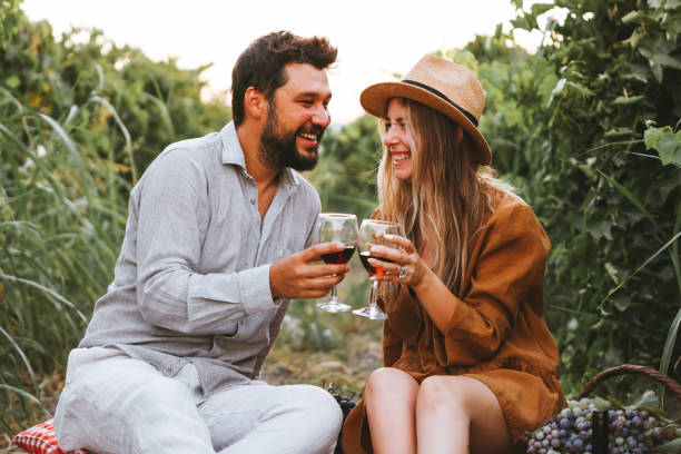istock Couple clinking red wine glass in a Vineyard during sunset. 1419706014
