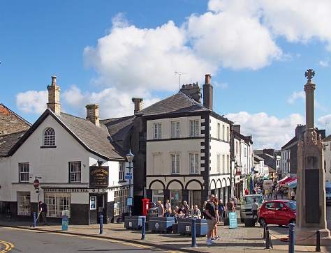 Ulverston, cumbria, united kingdom - 16 september 2021: view of the town centre in ulverston cumbria with people walking past shops and the weekly market