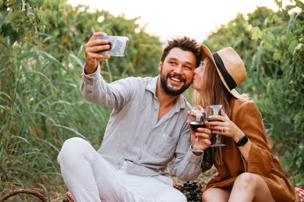 istock Couple clinking red wine glass in a Vineyard during sunset. 1419709425