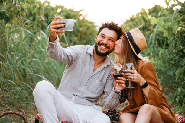 istock Couple clinking red wine glass in a Vineyard during sunset. 1419709459