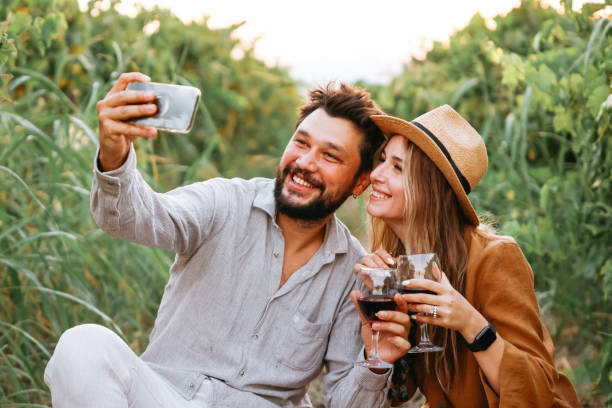 istock Couple clinking red wine glass in a Vineyard during sunset. 1419709519