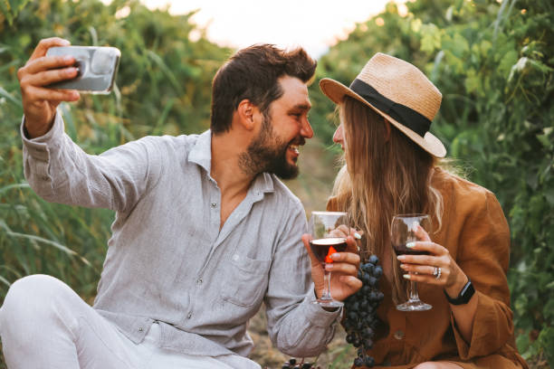 istock Couple clinking red wine glass in a Vineyard during sunset. 1419709720