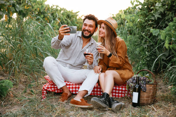 istock Couple clinking red wine glass in a Vineyard during sunset. 1419710147