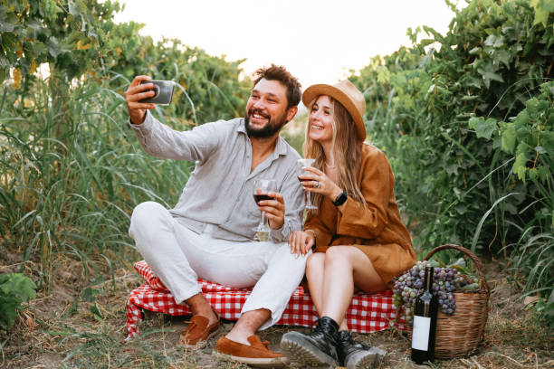 istock Couple clinking red wine glass in a Vineyard during sunset. 1419710284