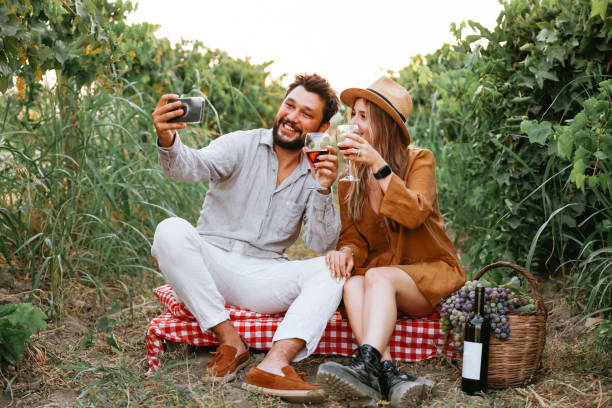 istock Couple clinking red wine glass in a Vineyard during sunset. 1419710932