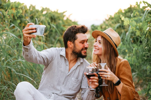 istock Couple clinking red wine glass in a Vineyard during sunset. 1419711071