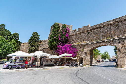 Rhodes Island, Greece - May 27, 2022: Mobile stalls selling gift shops and tourists shopping next to the historical fortifications on the Greek island of Rhodes Greece.