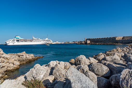 Rhodes, Greece - May 23, 2022: Huge luxury cruise ship bring tourists all summer long in the new Mandraki port of the City of Rhodes in the Greece.