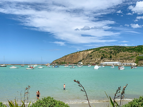 Two youngers are swimming at Friendly Bay, Oamaru, New Zealand.