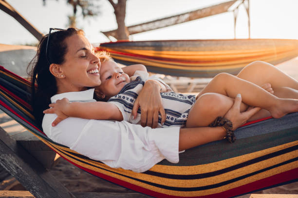 istock Mother and son lie in a swing on the beach 1419718439