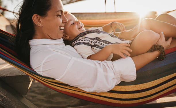 istock Mother and son lie in a swing on the beach 1419718483