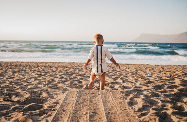istock A baby boy runs on a sandy beach 1419718615