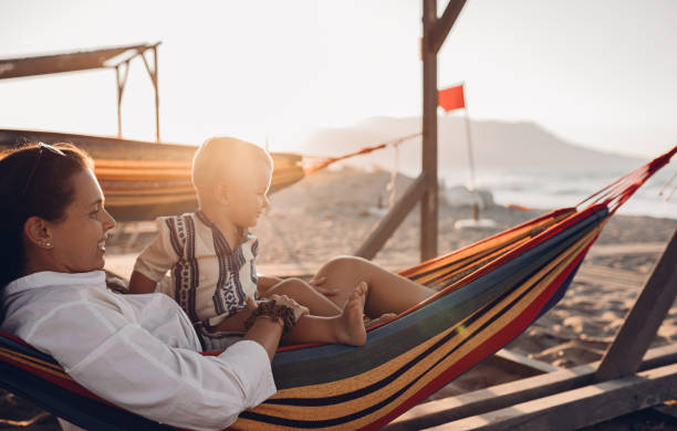 istock Mother and son lie in a swing on the beach 1419718944