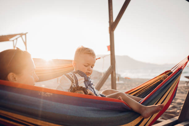 istock Mother and son lie in a swing on the beach 1419719015