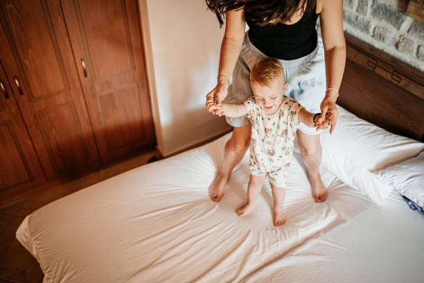 istock Mom and son jump on the bed 1419719258
