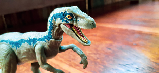 Velociraptor dinosaur toy on wooden table