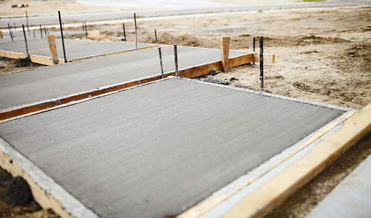 Concrete path being laid in front yard landscaping