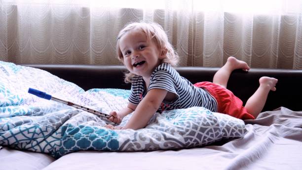 Baby learns to play on penny whistle at home.
