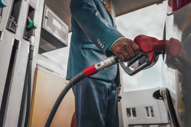 young man refuelling his modern car at petrol station - gas station gasoline refueling fuel pump imagens e fotografias de stock